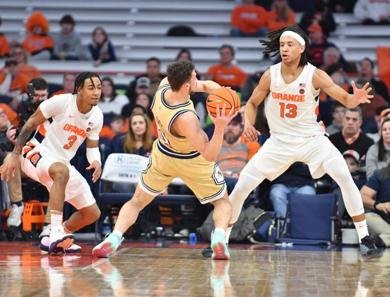 Feb 28, 2023; Syracuse, New York, USA; Georgia Tech Yellow Jackets guard Lance Terry (0) makes an awkward pass as Syracuse Orange forward Benny Williams (13) and guard Judah Mintz (3) defend in the second half at the JMA Wireless Dome. Mandatory Credit: Mark Konezny-USA TODAY Sports