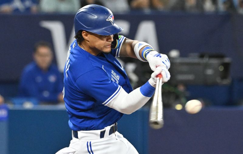 Aug 26, 2023; Toronto, Ontario, CAN;  Toronto Blue Jays shortstop Santiago Espinal (5) hits an RBI double against the Cleveland Guardians in the fourth inning at Rogers Centre. Mandatory Credit: Dan Hamilton-USA TODAY Sports