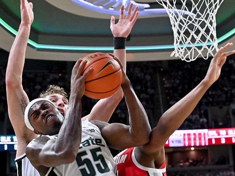 Feb 22, 2026; East Lansing, Michigan, USA;  Michigan State Spartans forward Coen Carr (55) brings down a defensive rebound against the Ohio State Buckeyes during the first half at Jack Breslin Student Events Center. Mandatory Credit: Dale Young-Imagn Images