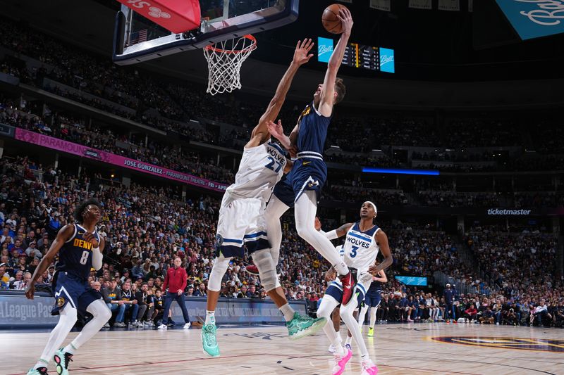 DENVER, CO - APRIL 10: Christian Braun #0 of the Denver Nuggets dunks the ball on Rudy Gobert #27 of the Minnesota Timberwolves on April 10, 2024 at the Ball Arena in Denver, Colorado. NOTE TO USER: User expressly acknowledges and agrees that, by downloading and/or using this Photograph, user is consenting to the terms and conditions of the Getty Images License Agreement. Mandatory Copyright Notice: Copyright 2024 NBAE (Photo by Garrett Ellwood/NBAE via Getty Images)