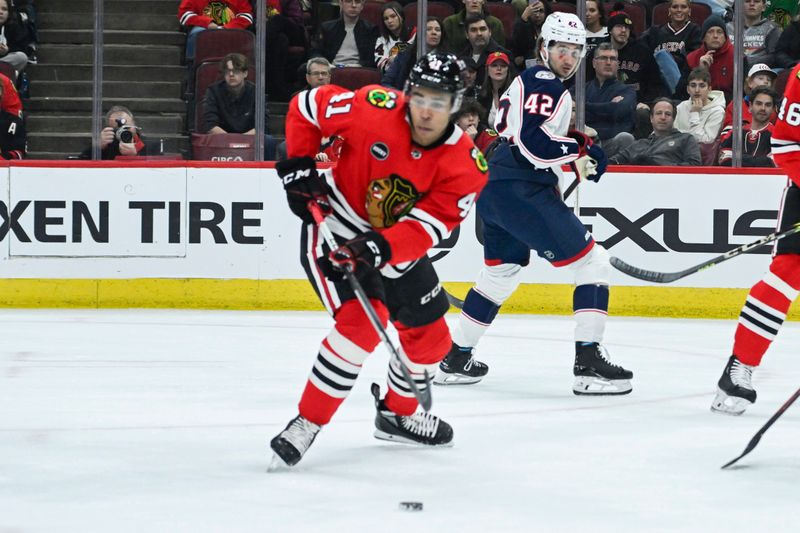 Mar 2, 2024; Chicago, Illinois, USA;  Chicago Blackhawks right wing Taylor Raddysh (11) chases the puck against the Columbus Blue Jackets during the first period at the  United Center. Mandatory Credit: Matt Marton-USA TODAY Sports
