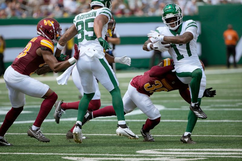 New York Jets wide receiver Malachi Corley (17) runs with the ball as Washington Commanders safety Jeremy Reaves (39) defends during the first half of an NFL preseason football game Saturday, Aug. 10, 2024, in East Rutherford. N.J. (AP Photo/Pamela Smith)