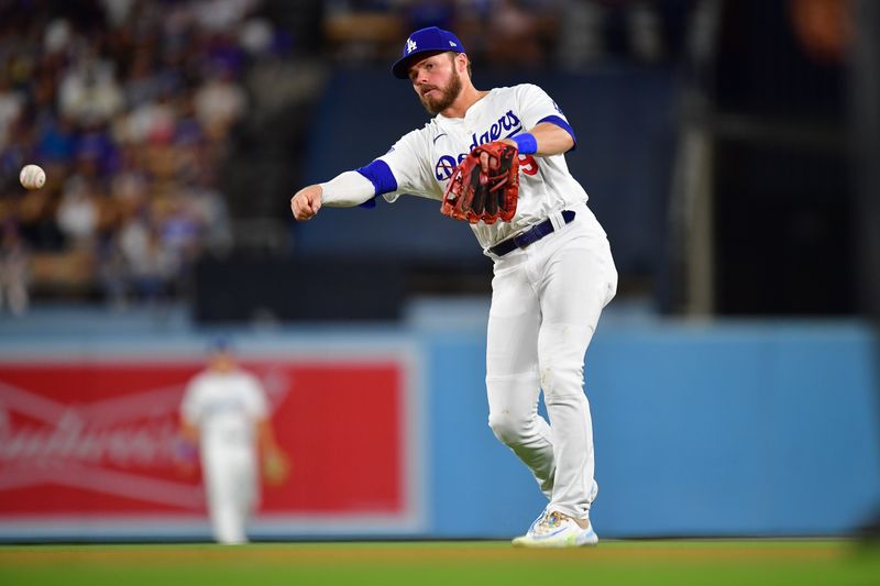 Aug 19, 2024; Los Angeles, California, USA; Los Angeles Dodgers second baseman Gavin Lux (9) throws to first for the out against Seattle Mariners third baseman Josh Rojas (4) during the eighth inning at Dodger Stadium. Mandatory Credit: Gary A. Vasquez-USA TODAY Sports