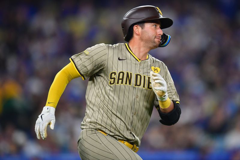 Sep 24, 2024; Los Angeles, California, USA; San Diego Padres catcher Kyle Higashioka (20) runs after hitting a single against the Los Angeles Dodgers during the seventh inning at Dodger Stadium. Mandatory Credit: Gary A. Vasquez-Imagn Images