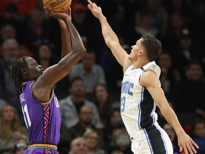 PHOENIX, ARIZONA - NOVEMBER 18: Bol Bol #11 of the Phoenix Suns attempts a shot over Tristan da Silva #23 of the Orlando Magic during the first half of the NBA game at Footprint Center on November 18, 2024 in Phoenix, Arizona.  NOTE TO USER: User expressly acknowledges and agrees that, by downloading and/or using this photograph, user is consenting to the terms and conditions of the Getty Images License Agreement. (Photo by Christian Petersen/Getty Images)