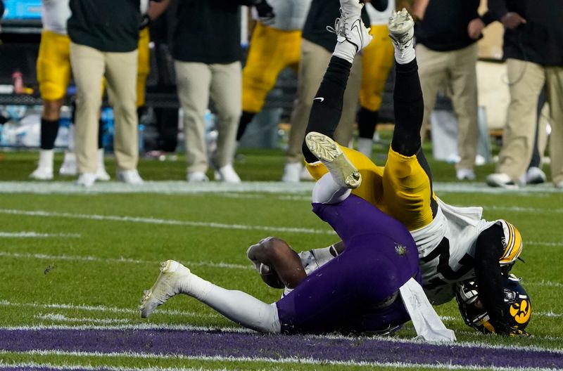 Nov 4, 2023; Chicago, Illinois, USA; Iowa Hawkeyes defensive back Jermari Harris (27) sacks Northwestern Wildcats quarterback Brendan Sullivan (6) to end the game during the second half at Wrigley Field. Mandatory Credit: David Banks-USA TODAY Sports