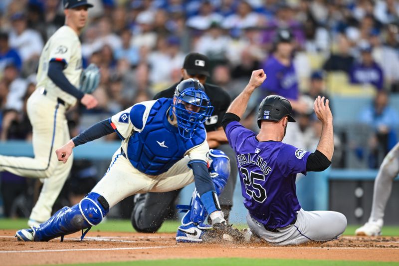 Sep 21, 2024; Los Angeles, California, USA; Colorado Rockies catcher Jacob Stallings (25) slides into home plate to score against Los Angeles Dodgers catcher Hunter Feduccia (67) during the second inning at Dodger Stadium. Mandatory Credit: Jonathan Hui-Imagn Images