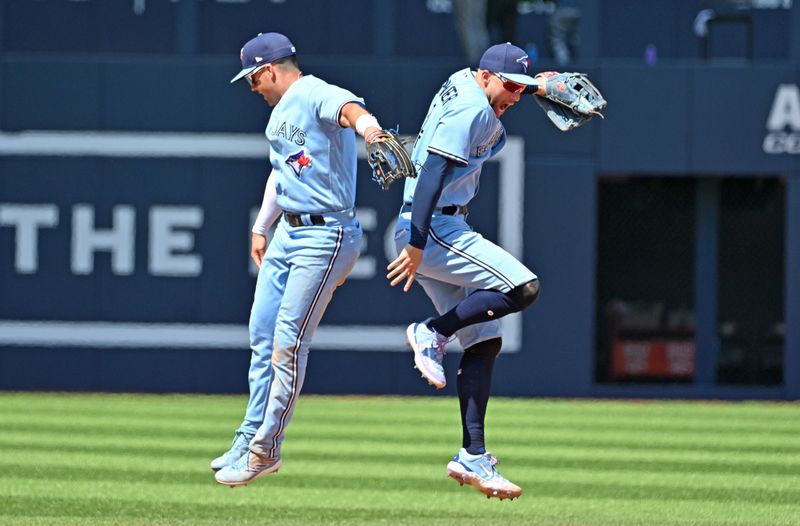 Jun 1, 2023; Toronto, Ontario, CAN;   Toronto Blue Jays right fielder George Springer (4) and second baseman Whit Merrifield (15) celebrate a win over the Milwaukee Brewers at Rogers Centre. Mandatory Credit: Dan Hamilton-USA TODAY Sports