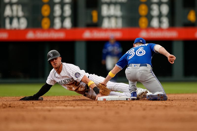 Sep 3, 2023; Denver, Colorado, USA; Colorado Rockies left fielder Nolan Jones (22) safely steals second against Toronto Blue Jays second baseman Davis Schneider (36) in the third inning at Coors Field. Mandatory Credit: Isaiah J. Downing-USA TODAY Sports