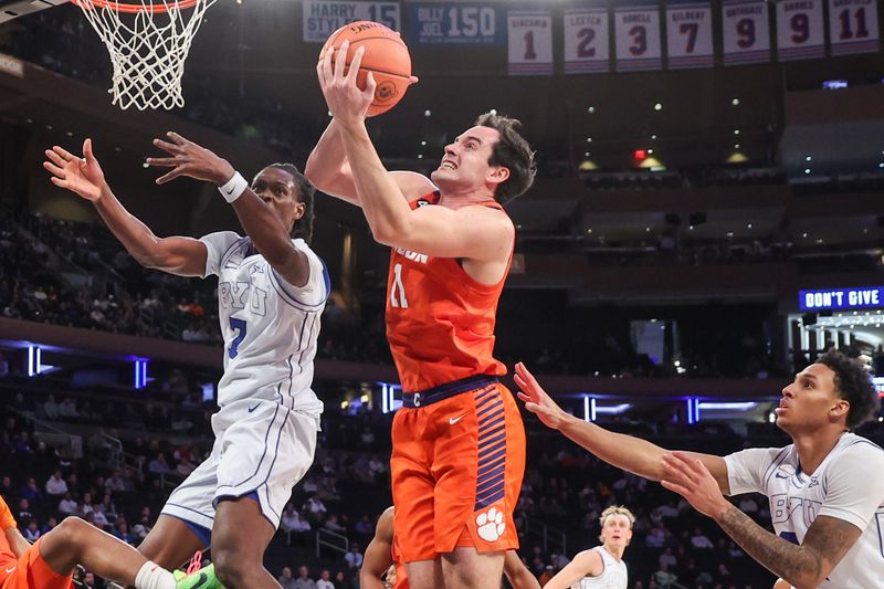 Dec 9, 2025; New York, New York, USA;  Clemson Tigers forward Nick Davidson (11) grabs a rebound from BYU Cougars forward Khadim Mboup (7) in the first half at Madison Square Garden. Mandatory Credit: Wendell Cruz-Imagn Images