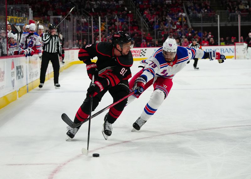 Mar 12, 2024; Raleigh, North Carolina, USA; Carolina Hurricanes center Evgeny Kuznetsov (92) skates with the puck past New York Rangers defenseman K'Andre Miller (79) during the third period at PNC Arena. Mandatory Credit: James Guillory-USA TODAY Sports