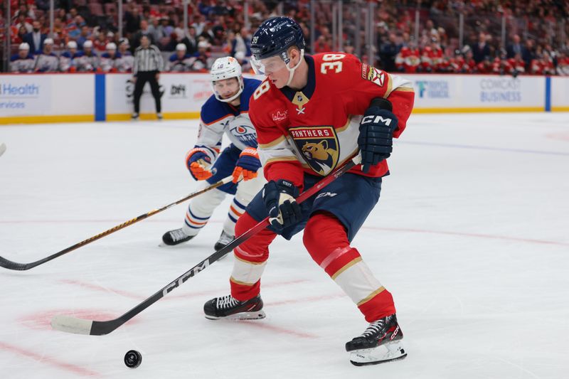 Nov 22, 2025; Sunrise, Florida, USA; Florida Panthers right wing Jack Devine (38) moves the puck against Edmonton Oilers left wing Zach Hyman (18) during the first period at Amerant Bank Arena. Mandatory Credit: Sam Navarro-Imagn Images