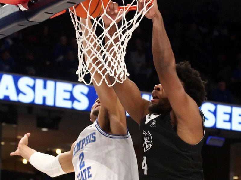 Jan 31, 2024; Memphis, Tennessee, USA; Rice Owls guard Anthony Selden (4) dunks over Memphis Tigers forward Nicholas Jourdain (2) during the second half at FedExForum. Mandatory Credit: Petre Thomas-USA TODAY Sports