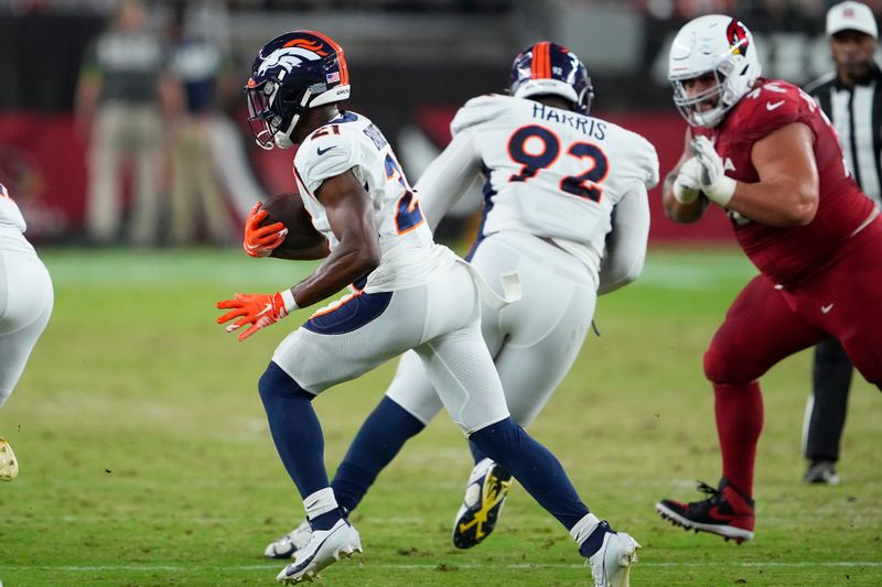 Denver Broncos cornerback Essang Bassey runs with an interception during the first half of an NFL preseason football game against the Arizona Cardinals in Glendale, Ariz., Friday, Aug. 11, 2023. (AP Photo/Matt York)