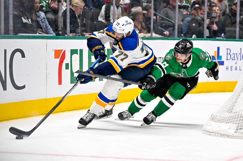 Dec 14, 2024; Dallas, Texas, USA; St. Louis Blues defenseman Pierre-Olivier Joseph (77) clears the puck in front of Dallas Stars center Sam Steel (18) during the second period at American Airlines Center. Mandatory Credit: Jerome Miron-Imagn Images