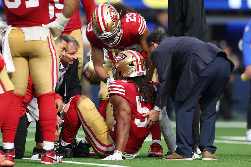 San Francisco 49ers linebacker Fred Warner, middle, is tended to during an NFL football game against the Los Angeles Rams, Sunday, Sept. 22, 2024, in Inglewood, Calif. (AP Photo/Ryan Sun)