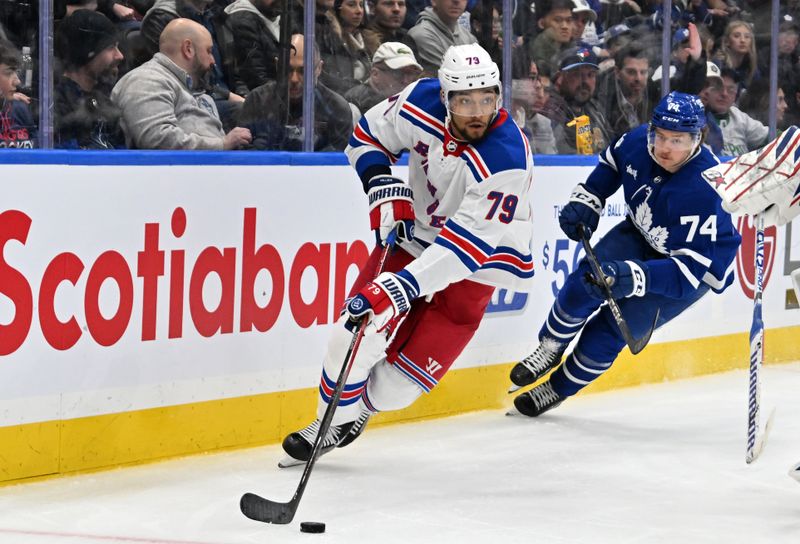 Mar 2, 2024; Toronto, Ontario, CAN;  New York Rangers defenseman K'Andre Miller (79) skates the puck away from Toronto Maple Leafs forward Bobby McMann (74) in the third period at Scotiabank Arena. Mandatory Credit: Dan Hamilton-USA TODAY Sports