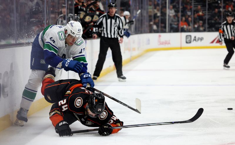 Mar 3, 2024; Anaheim, California, USA; Vancouver Canucks defenseman Noah Juulsen (47) checks Anaheim Ducks center Bo Groulx (24) during the first period at Honda Center. Mandatory Credit: Jason Parkhurst-USA TODAY Sports