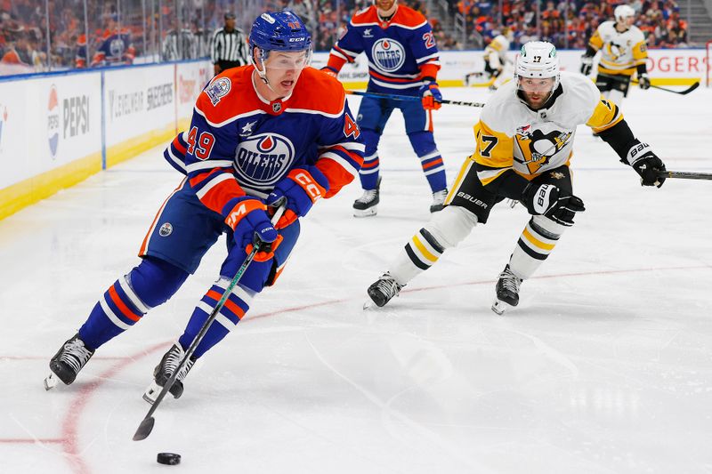 Oct 25, 2024; Edmonton, Alberta, CAN; Edmonton Oilers defensemen Ty Emberson (49) looks to make a pass in front of Pittsburgh Penguins forward Bryan Rust (17) during the second period at Rogers Place. Mandatory Credit: Perry Nelson-Imagn Images