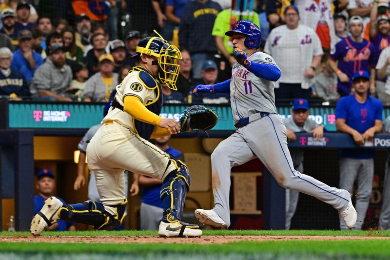Oct 1, 2024; Milwaukee, Wisconsin, USA; New York Mets second base Jose Iglesias (11) slides safely into home plate against Milwaukee Brewers catcher William Contreras (24) during the fifth inning in game one of the Wildcard round for the 2024 MLB Playoffs at American Family Field. Mandatory Credit: Benny Sieu-Imagn Images