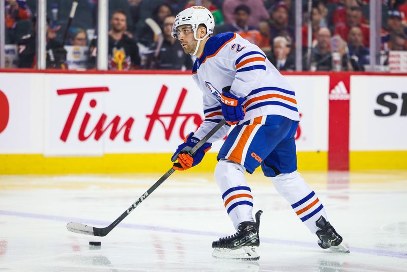 Apr 6, 2024; Calgary, Alberta, CAN; Edmonton Oilers defenseman Evan Bouchard (2) controls the puck against the Calgary Flames during the third period at Scotiabank Saddledome. Mandatory Credit: Sergei Belski-USA TODAY Sports