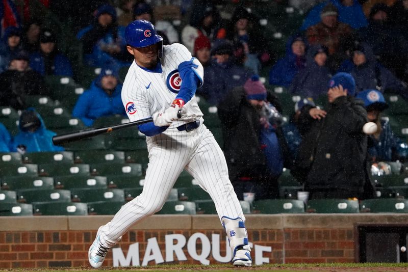 Apr 3, 2024; Chicago, Illinois, USA; Chicago Cubs right fielder Seiya Suzuki (27) hits a home run against the Colorado Rockies during the fifth inning at Wrigley Field. Mandatory Credit: David Banks-USA TODAY Sports