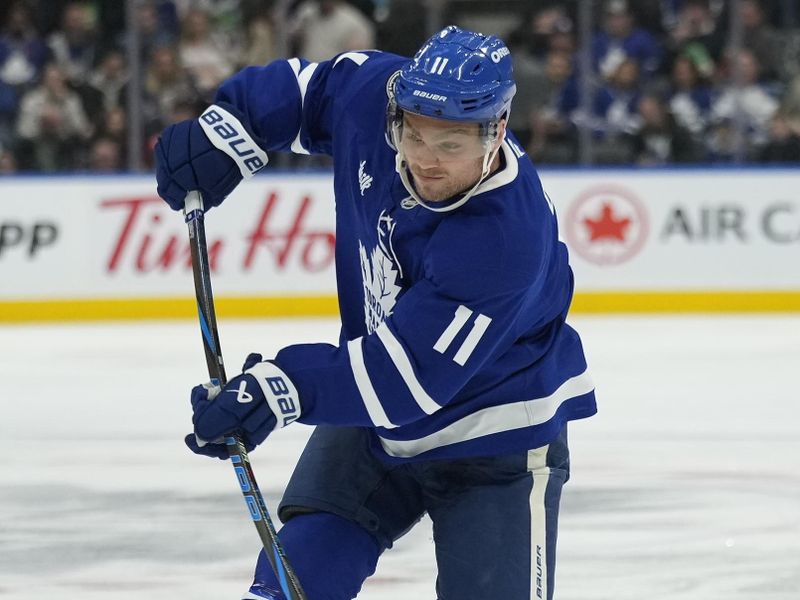 Nov 8, 2024; Toronto, Ontario, CAN; Toronto Maple Leafs forward Max Domi (11) shoots the puck against the Detroit Red Wings during the third period at Scotiabank Arena. Mandatory Credit: John E. Sokolowski-Imagn Images