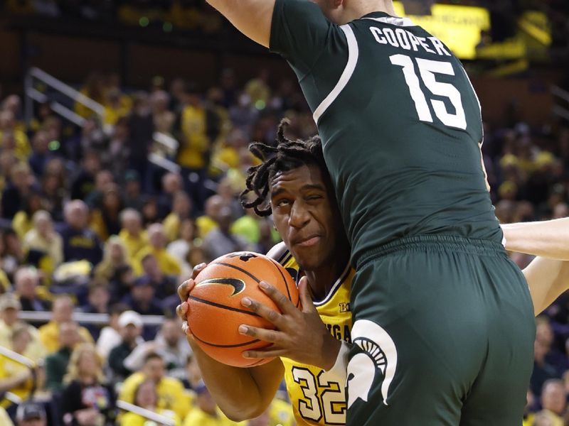 Feb 18, 2023; Ann Arbor, Michigan, USA;  Michigan Wolverines forward Tarris Reed Jr. (32) controls the ball against Michigan State Spartans center Carson Cooper (15) in the first half at Crisler Center. Mandatory Credit: Rick Osentoski-USA TODAY Sports