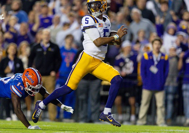 Nov 11, 2023; Baton Rouge, Louisiana, USA;  LSU Tigers quarterback Jayden Daniels (5) rushes for a touchdown against Florida Gators safety Jordan Castell (14) during the first half at Tiger Stadium. Mandatory Credit: Stephen Lew-USA TODAY Sports