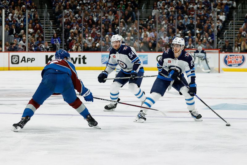 Apr 26, 2024; Denver, Colorado, USA; Winnipeg Jets left wing Kyle Connor (81) controls the puck against Colorado Avalanche defenseman Cale Makar (8) as defenseman Dylan Samberg (54) defends in the first period in game three of the first round of the 2024 Stanley Cup Playoffs at Ball Arena. Mandatory Credit: Isaiah J. Downing-USA TODAY Sports