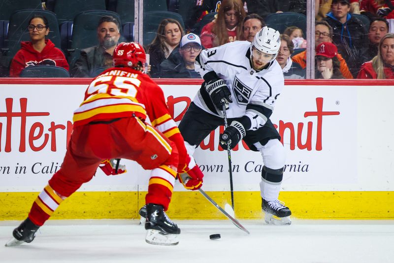 Mar 28, 2023; Calgary, Alberta, CAN; Los Angeles Kings right wing Adrian Kempe (9) controls the puck in front of Calgary Flames defenseman Noah Hanifin (55) during the third period at Scotiabank Saddledome. Mandatory Credit: Sergei Belski-USA TODAY Sports