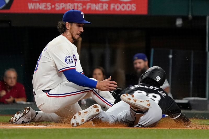 Jul 22, 2024; Arlington, Texas, USA; Texas Rangers starting pitcher Michael Lorenzen (23) tags out Chicago White Sox center fielder Luis Robert Jr. (88) at home on runner's fielder's choice.at Globe Life Field. Mandatory Credit: Raymond Carlin III-USA TODAY Sports