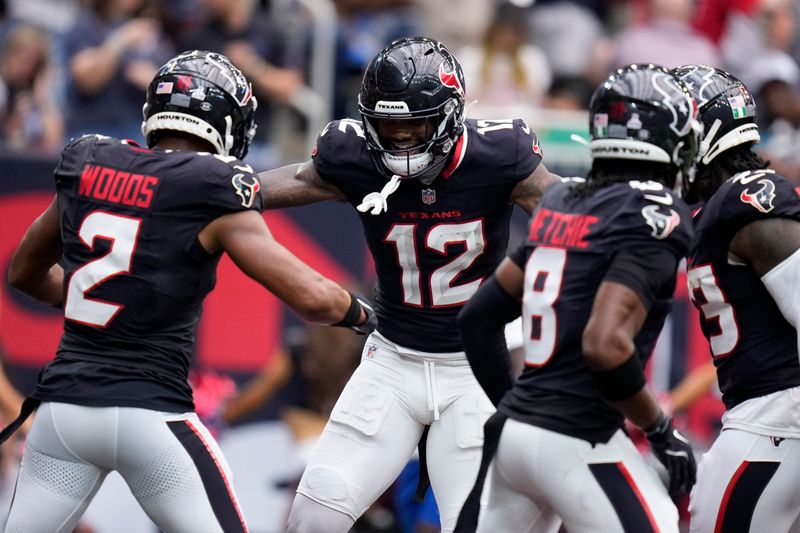 Houston Texans wide receiver Nico Collins (12) celebrates with teammate Robert Woods (2) after catching a 3-yard touchdown pass during the first half of an NFL football game against the Jacksonville Jaguars, Sunday, Sept. 29, 2024, in Houston. (AP Photo/Eric Christian Smith)