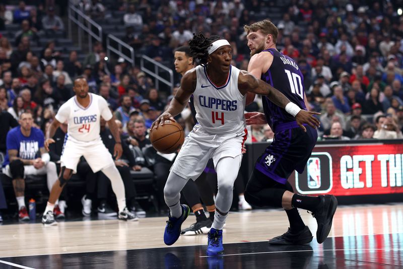 LOS ANGELES, CALIFORNIA - FEBRUARY 25: Terance Mann #14 of the Los Angeles Clippers drives past Domantas Sabonis #10 of the Sacramento Kings during the first quarter at Crypto.com Arena on February 25, 2024 in Los Angeles, California. NOTE TO USER: User expressly acknowledges and agrees that, by downloading and or using this photograph, User is consenting to the terms and conditions of the Getty Images License Agreement.  (Photo by Katelyn Mulcahy/Getty Images)