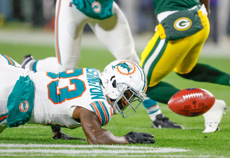 Miami Dolphins wide receiver Malik Washington (83) fumbles a punt during a NFL football game against the Green Bay Packers Thursday, Nov. 28, 2024, in Green Bay, Wis. (AP Photo/Jeffrey Phelps