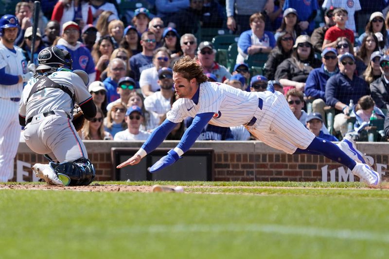 Apr 21, 2024; Chicago, Illinois, USA; Miami Marlins catcher Nick Fortes (4) tags out Chicago Cubs second baseman at home plate during the fourth inning Nico Hoerner (2) at Wrigley Field. Mandatory Credit: David Banks-USA TODAY Sports