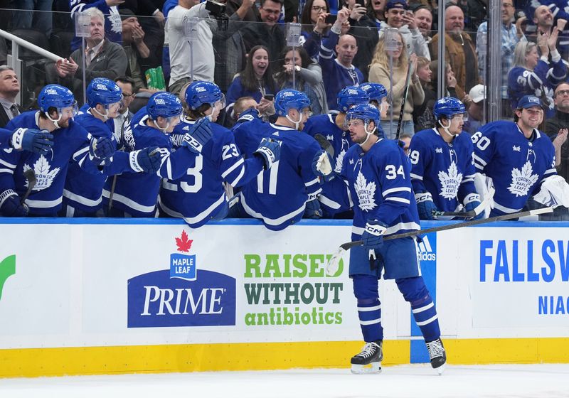 Apr 13, 2024; Toronto, Ontario, CAN; Toronto Maple Leafs center Auston Matthews (34) scores his 69th goal of the season and celebrates at the bench against the Detroit Red Wings during the second period at Scotiabank Arena. Mandatory Credit: Nick Turchiaro-USA TODAY Sports