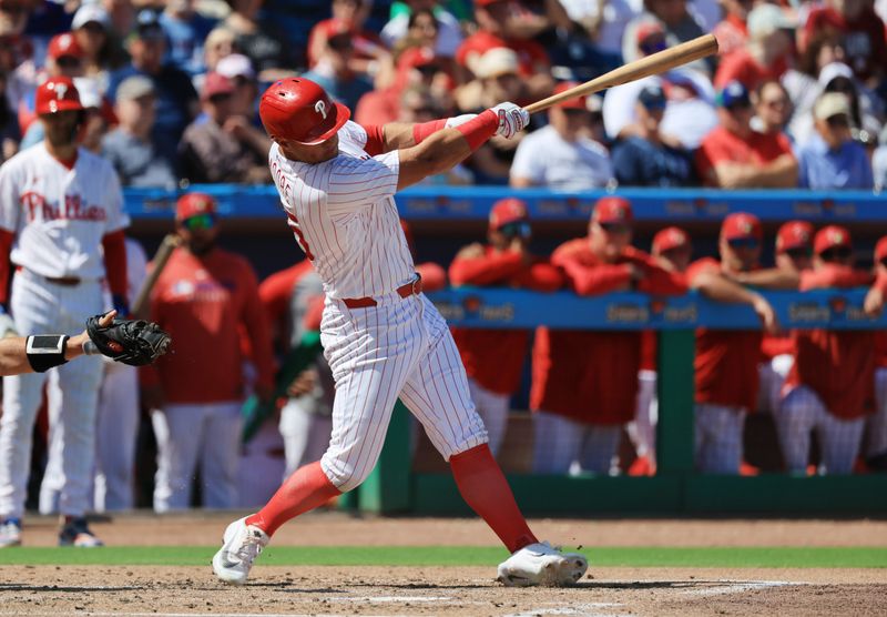 Mar 5, 2026; Clearwater, Florida, USA;  Philadelphia Phillies designated hitter Dylan Moore (25) hits a 2-RBI single during the second inning against the Boston Red Sox at BayCare Ballpark. Mandatory Credit: Kim Klement Neitzel-Imagn Images