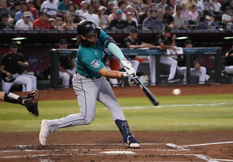 Jul 29, 2023; Phoenix, Arizona, USA; Seattle Mariners third baseman Eugenio Suarez (28) hits a sacrifice fly RBI against the Arizona Diamondbacks during the second inning at Chase Field. Mandatory Credit: Joe Camporeale-USA TODAY Sports