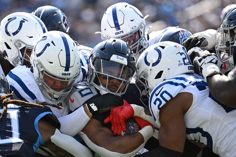 Tennessee Titans running back Tony Pollard (20) is stopped by the Indianapolis Colts during the second half of an NFL football game, Sunday, Oct. 13, 2024, in Nashville, Tenn. (AP Photo/John Amis)