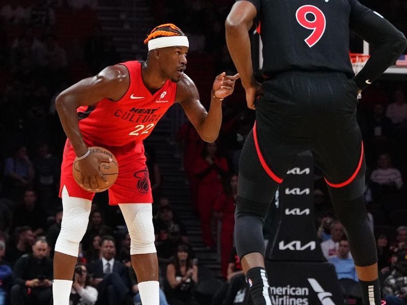 MIAMI, FLORIDA - DECEMBER 12: Jimmy Butler #22 of the Miami Heat looks to make a pass against RJ Barrett #9 of the Toronto Raptors during the first quarter at Kaseya Center on December 12, 2024 in Miami, Florida. NOTE TO USER: User expressly acknowledges and agrees that, by downloading and or using this Photograph, user is consenting to the terms and conditions of the Getty Images License Agreement. (Photo by Rich Storry/Getty Images)