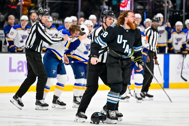 Jan 18, 2025; Salt Lake City, Utah, USA; Linesperson Travis Gawryletz (67) breaks up a fight between Utah Hockey Club center Liam O'Brien (38) and St. Louis Blues defenseman Tyler Tucker (75) during first period at the Delta Center. Mandatory Credit: Christopher Creveling-Imagn Images