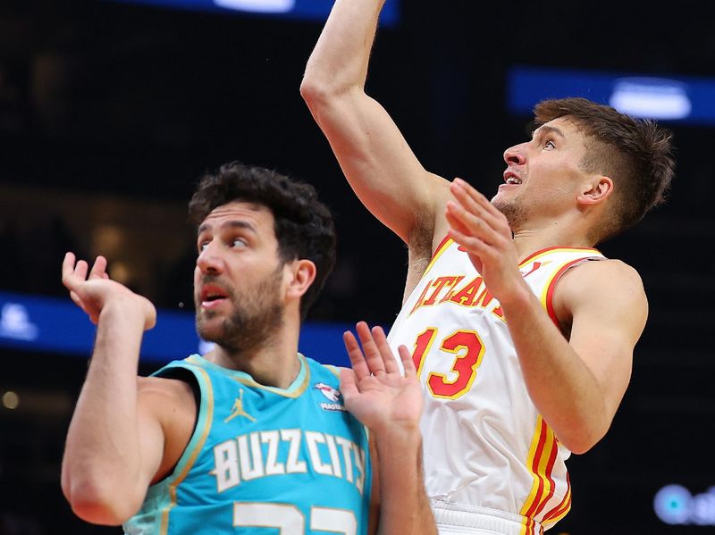 ATLANTA, GEORGIA - MARCH 23:  Bogdan Bogdanovic #13 of the Atlanta Hawks attempts a shot against Vasa Micic #22 of the Charlotte Hornets during the first quarter at State Farm Arena on March 23, 2024 in Atlanta, Georgia.  NOTE TO USER: User expressly acknowledges and agrees that, by downloading and/or using this photograph, user is consenting to the terms and conditions of the Getty Images License Agreement.  (Photo by Kevin C. Cox/Getty Images)
