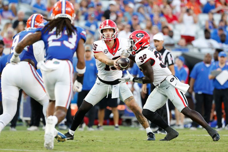 Oct 28, 2023; Jacksonville, Florida, USA; Georgia Bulldogs quarterback Carson Beck (15) hands off to running back Daijun Edwards (30) in the second half at EverBank Stadium. Mandatory Credit: Jeff Swinger-USA TODAY Sports