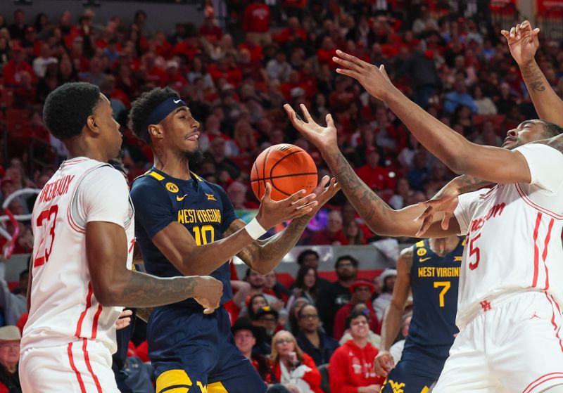 Jan 15, 2025; Houston, Texas, USA; West Virginia Mountaineers guard Sencire Harris (10) grabs a rebound  against Houston Cougars forward Ja'Vier Francis (5) in the first half at Fertitta Center. Mandatory Credit: Thomas Shea-Imagn Images