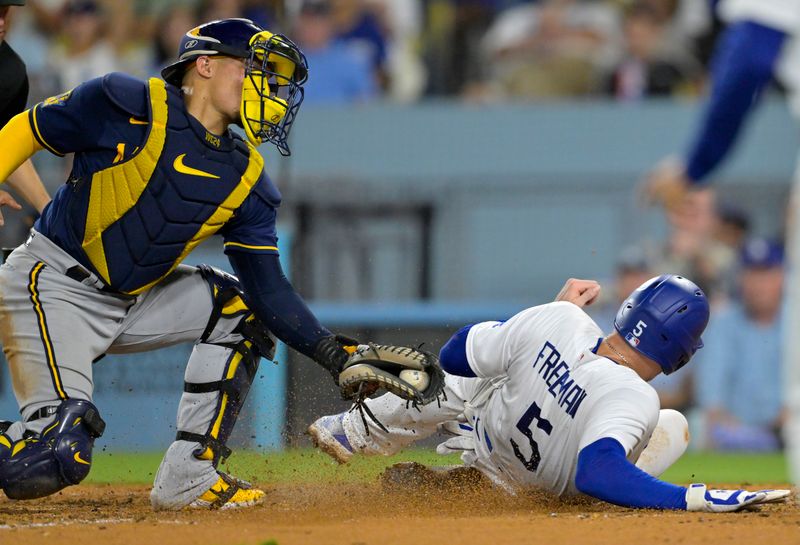 Aug 16, 2023; Los Angeles, California, USA;  Los Angeles Dodgers first baseman Freddie Freeman (5) beats the tag by Milwaukee Brewers catcher William Contreras (24) on a single by Los Angeles Dodgers catcher Will Smith (16) in the sixth inning at Dodger Stadium. Mandatory Credit: Jayne Kamin-Oncea-USA TODAY Sports