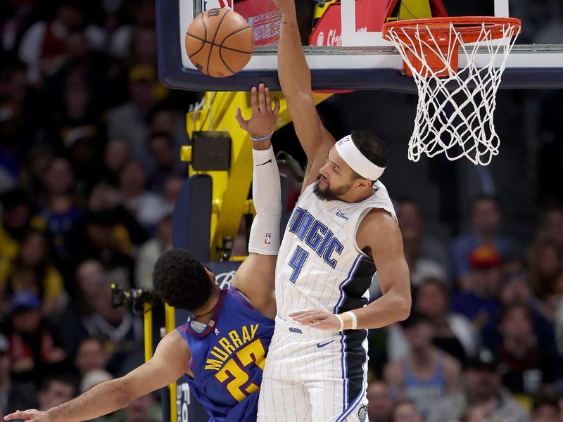 DENVER, COLORADO - JANUARY 05: Jamal Murray #27 of the Denver Nuggets is blocked going to the basket by Jalen Suggs #4 of the Orlando Magic in the first quarter at Ball Arena on January 05, 2024 in Denver, Colorado.  NOTE TO USER: User expressly acknowledges and agrees that, by downloading and or using this photograph, User is consenting to the terms and conditions of the Getty Images License Agreement.  (Photo by Matthew Stockman/Getty Images)