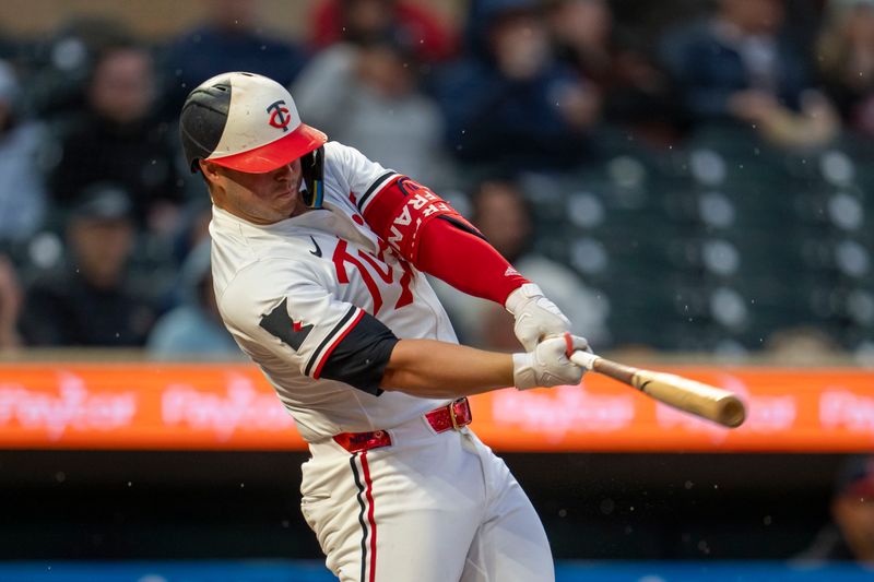 May 19, 2025; Minneapolis, Minnesota, USA; Minnesota Twins first baseman Ty France (13) hits a RBI single against the Cleveland Guardians in the first inning at Target Field. Mandatory Credit: Jesse Johnson-Imagn Images