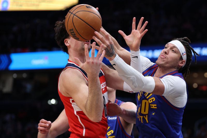 WASHINGTON, DC - JANUARY 21: Deni Avdija #8 of the Washington Wizards grabs a rebound in front of Aaron Gordon #50 of the Denver Nuggets during the first half at Capital One Arena on January 21, 2024 in Washington, DC. NOTE TO USER: User expressly acknowledges and agrees that, by downloading and or using this photograph, User is consenting to the terms and conditions of the Getty Images License Agreement. (Photo by Patrick Smith/Getty Images)