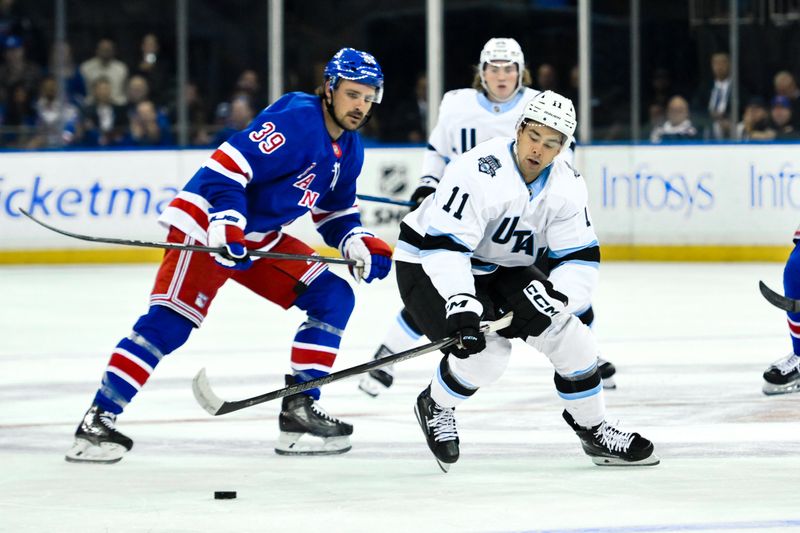 Oct 12, 2024; New York, New York, USA; Utah Hockey Club right wing Dylan Guenther (11) skates with the puck against New York Rangers center Sam Carrick (39) during the first period at Madison Square Garden. Mandatory Credit: John Jones-Imagn Images